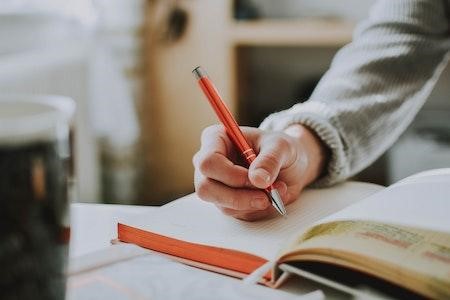 Persona escribiendo en un folio