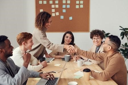 Reunión de personas con dos dándose la mano