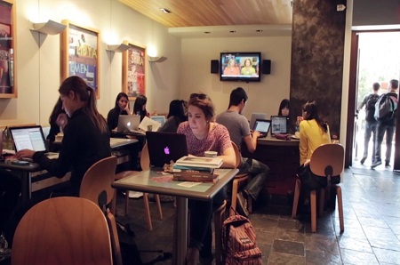 Estudiantes revisan sus laptops en la cafetería escolar