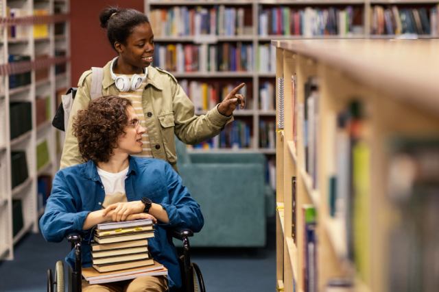 https://www.freepik.com/free-photo/girl-helping-her-colleague-wheelchair-choose-book-project_12296571.htm