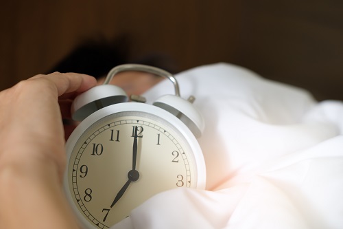 Reloj despertador entre paño blanco