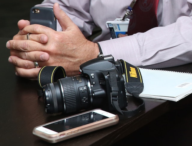 https://www.pexels.com/es-es/foto/camara-nikon-dslr-negra-al-lado-de-las-manos-de-la-persona-627602/