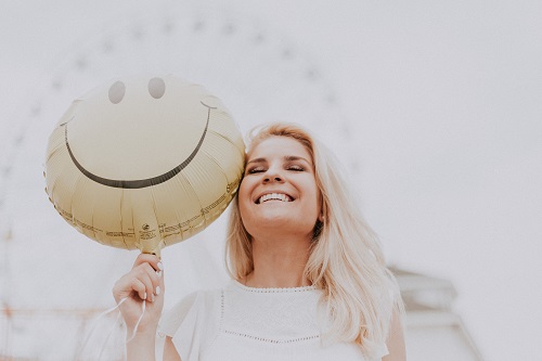 Mujer sonriente con un globo con una cara sonriente