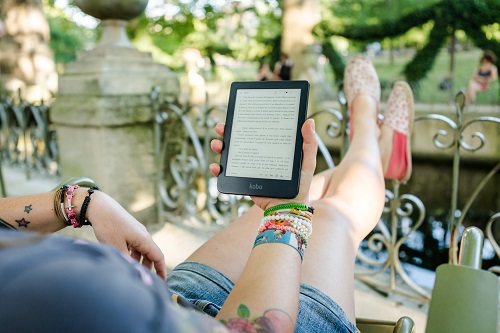 Chica leyendo un ebook en un parque