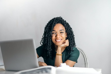 Chica joven sonriendo delante del ordenador